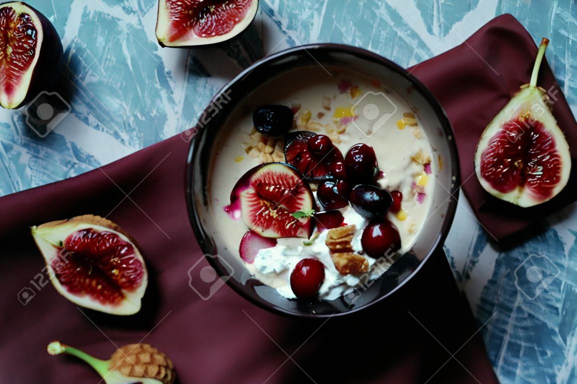 Overhead still life of smoothie bowl, belgian biscuit waffles with cottage cheese, fresh figs and cherry. Healthy vegetarian breakfast.