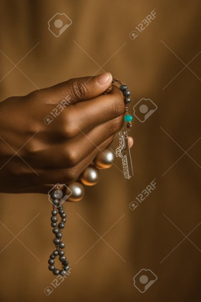 Manos de mujer rezando con un rosario