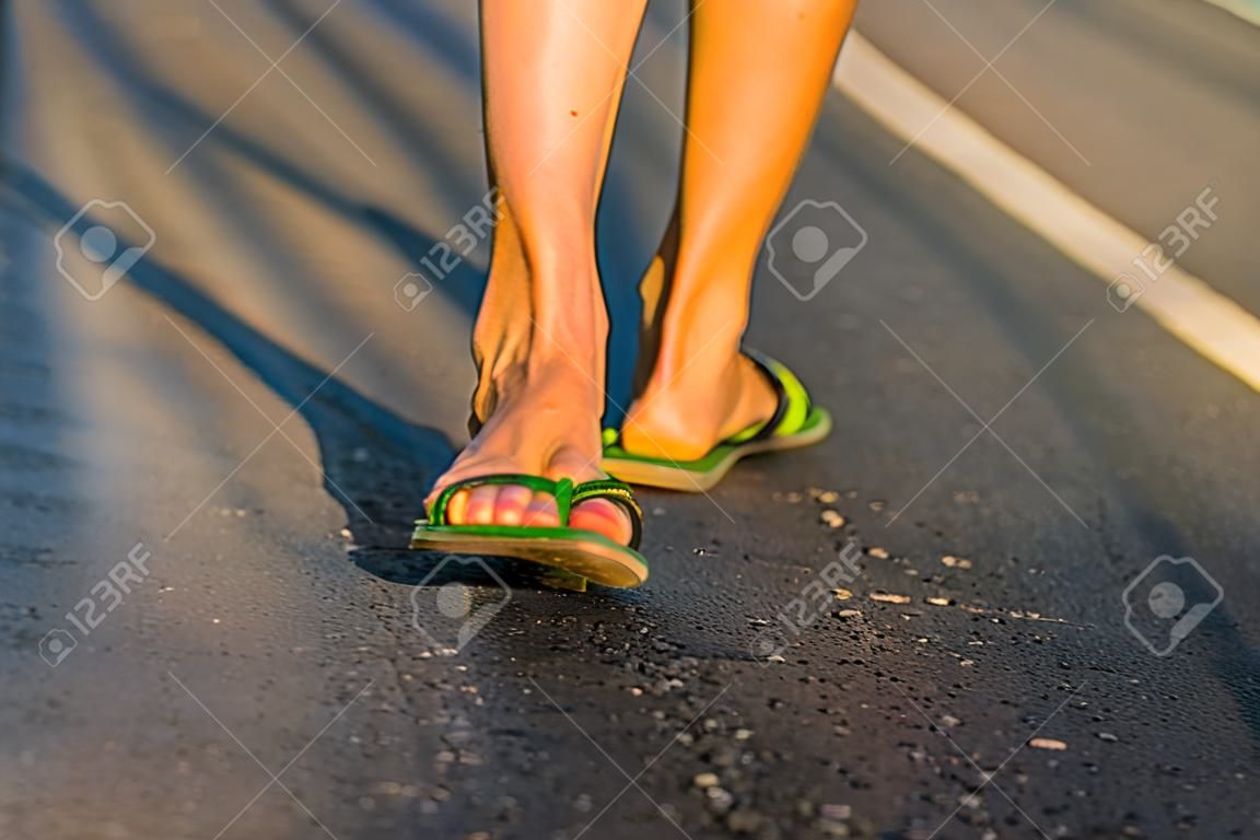 Cerca de los pies de la mujer caminando.