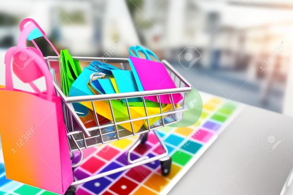 Concepto en línea de compras, bolsa de papel de colores en carro en la computadora portátil.