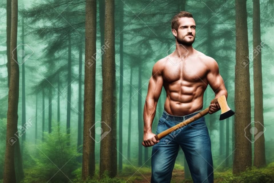 Sin camisa hombre musculoso físico leñador con el hacha en el bosque.