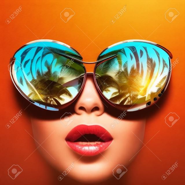 戴着太阳眼镜的女人，脸上有棕榈树的反光