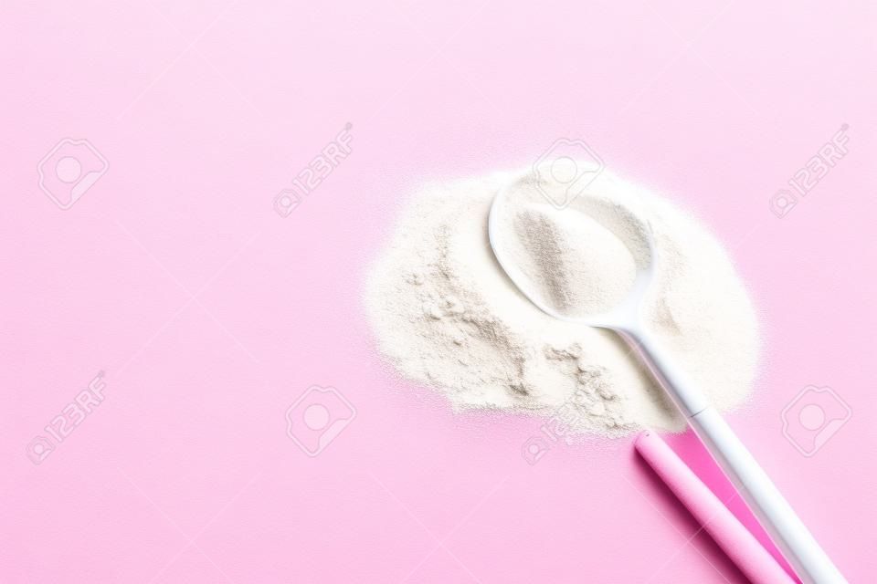Collagen powder on pink background. Extra protein intake. Natural beauty and health supplement for skin, bones, joints and gut. Plant or fish based. Flatlay, top view. Copy space for your text.