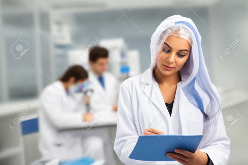 scientist make notes to the clipboard in the clinical laboratory.