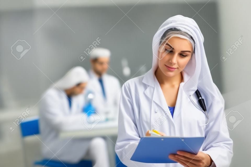 scientist make notes to the clipboard in the clinical laboratory.