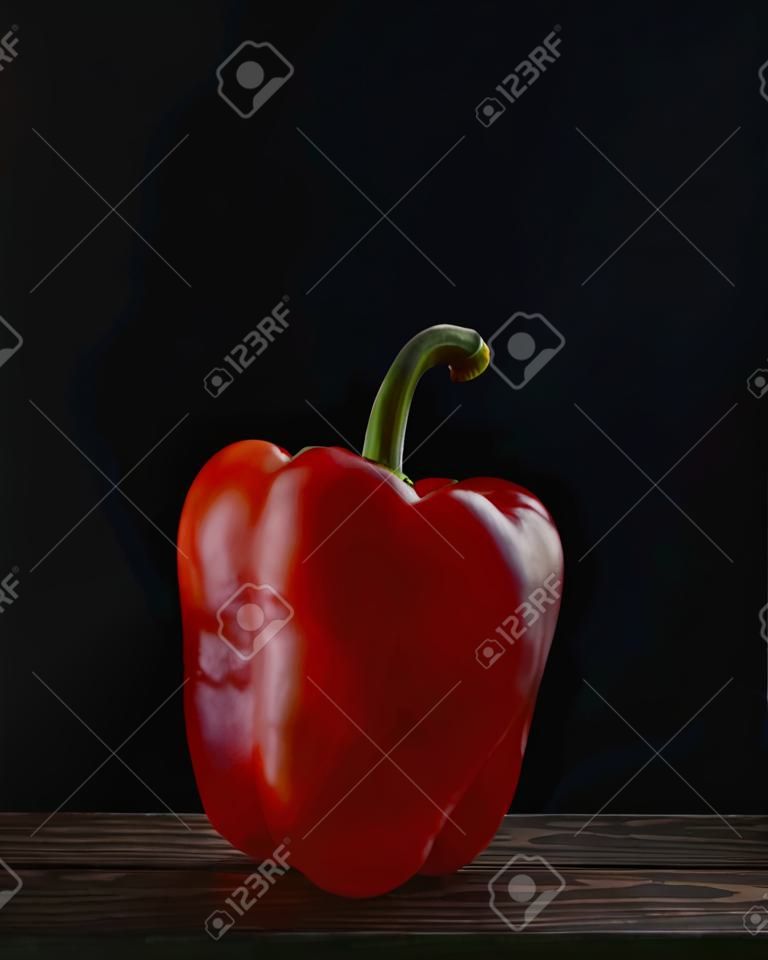 Red bell peppers on a dark wooden table on a black background.