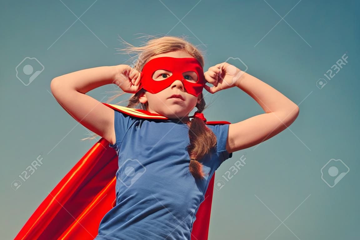 빨간색 우비에 재미있는 작은 전원 슈퍼 영웅 아이 (소녀). 슈퍼 히어로의 개념. 토닝 인스 타 그램 색상