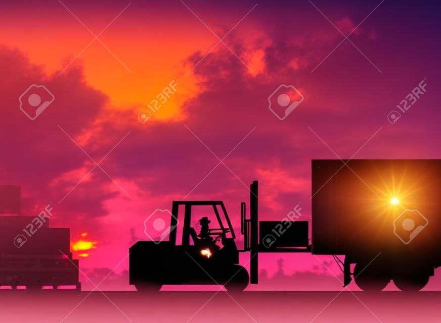 Silhouette driver of the truck was put in the car to transport cargo to customers, accurately and securely over blurred pastel background sunset shipping. Heavy industry and Transportation concept.