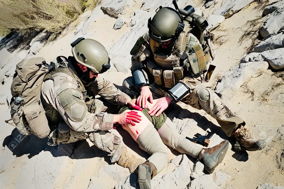 Ejército de Estados Unidos médico guardabosques tratamiento de las heridas de su compañero herido en armas en las montañas