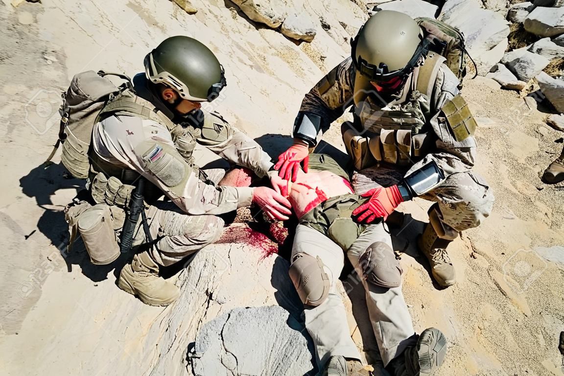 美國陸軍遊騎兵軍醫治療他受傷的同胞的創傷武器在山上