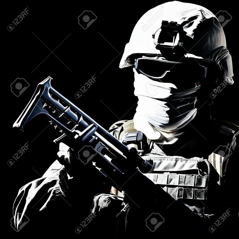 Ritratto di spalla della guerra, combattente del conflitto militare, soldato delle forze speciali dell'esercito, combattente delle forze antiterrorismo armato di fucile in casco da combattimento, occhiali e maschera ritagliati su sfondo nero
