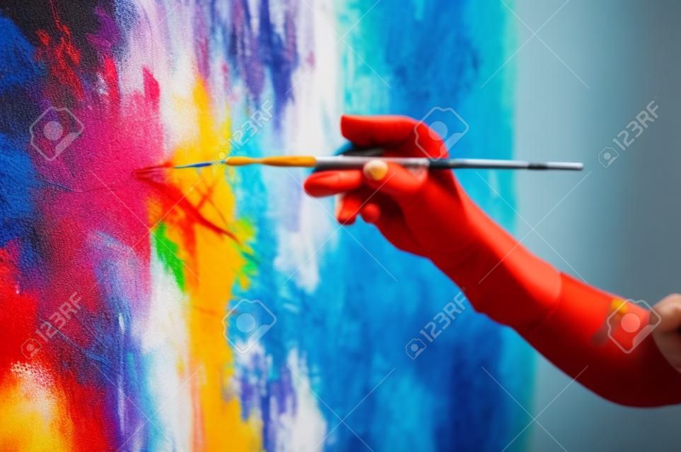 Closeup of an artist hand holding paintbrush. Moving paintbrush energetically and creating modern masterpiece. Artist art performance.