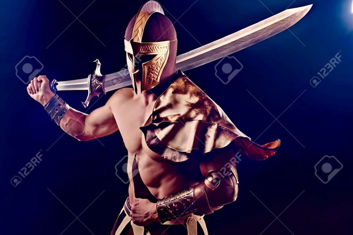 Retrato de guapo gladiador musculoso con espada. aislado. foto de estudio