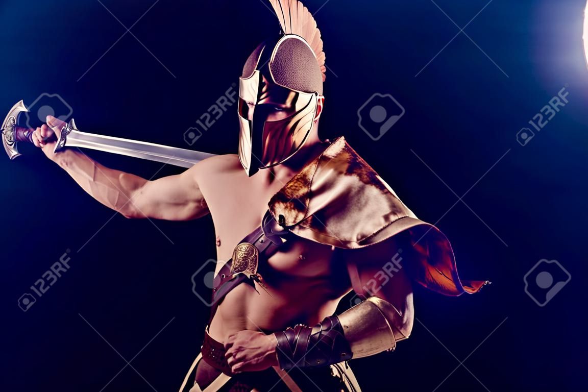 Retrato de guapo gladiador musculoso con espada. aislado. foto de estudio