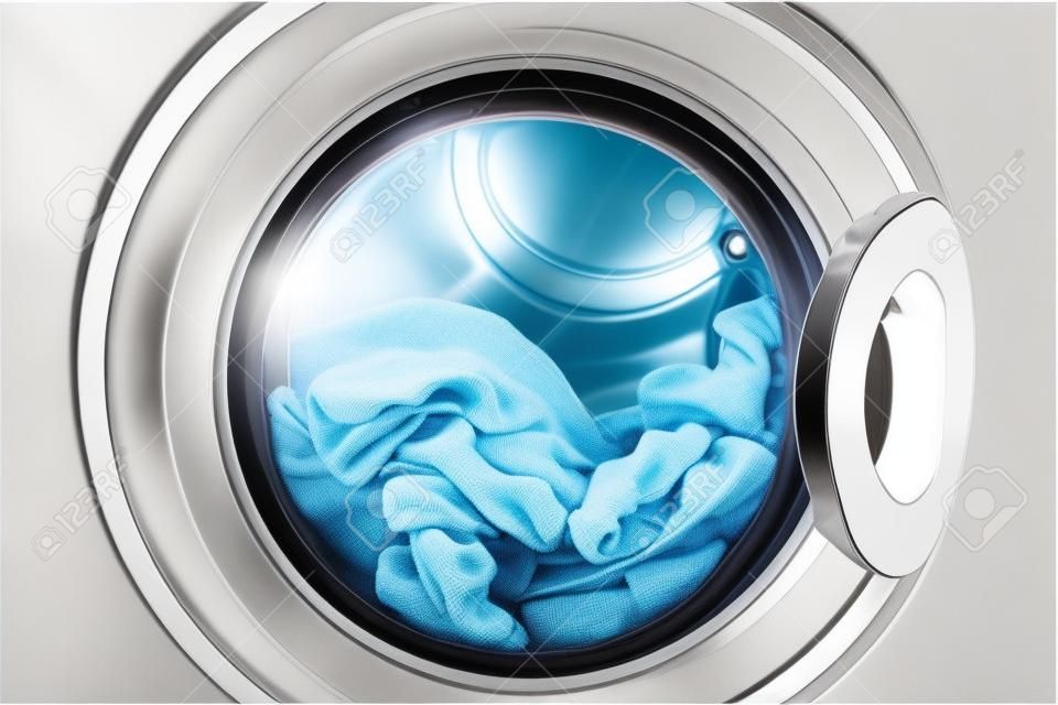 Closed round washing machine door with rotating garments inside. Focus in the center of dirty laundry and washing machine on the frame.