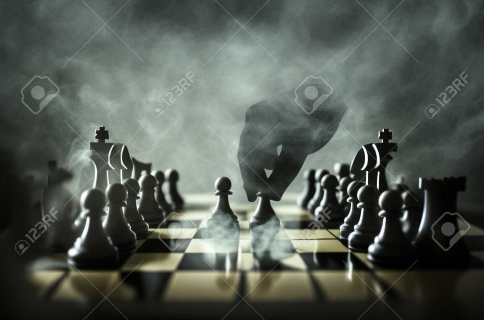 Conceito de jogo de tabuleiro de xadrez de ideias de negócios e ideias de competição e estratégia concep. Figuras de xadrez em um fundo escuro com fumaça e nevoeiro.