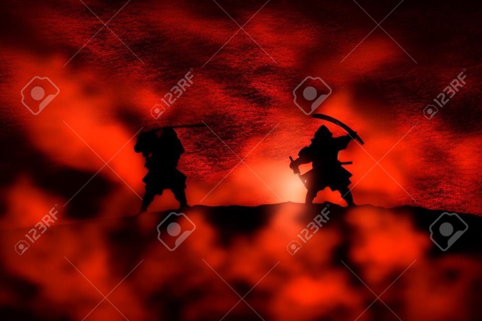 Silhouette of two samurais in duel. Picture with two samurais and sunset sky. Selective focus
