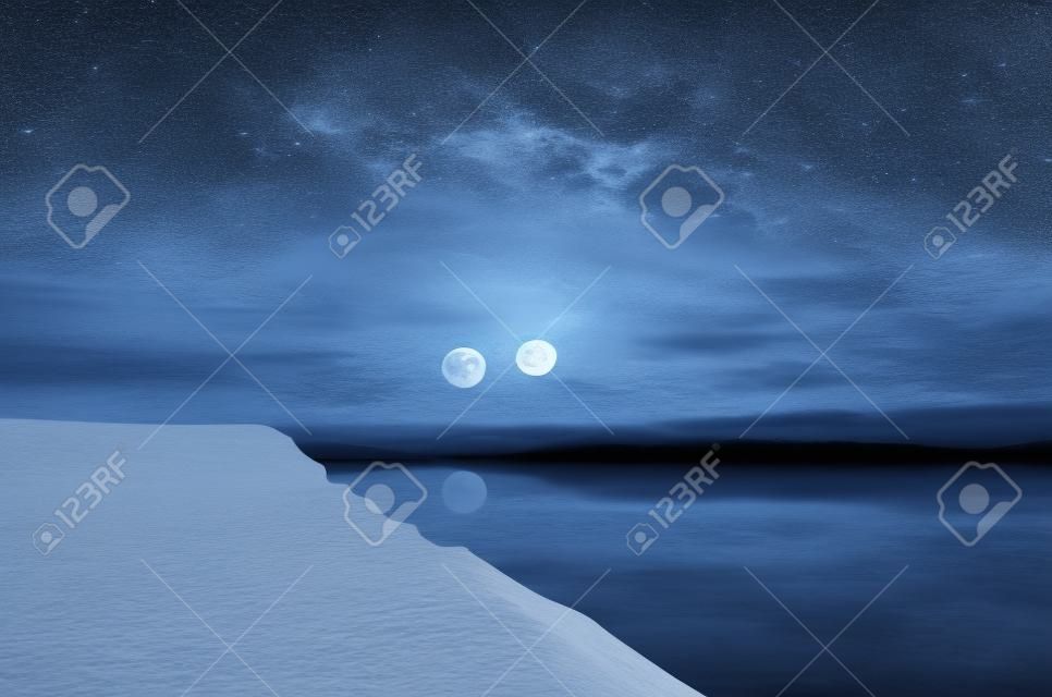 Paesaggio di splendida luna piena sulle montagne innevate riflesse nel fiume o misterioso cielo notturno con la luna piena