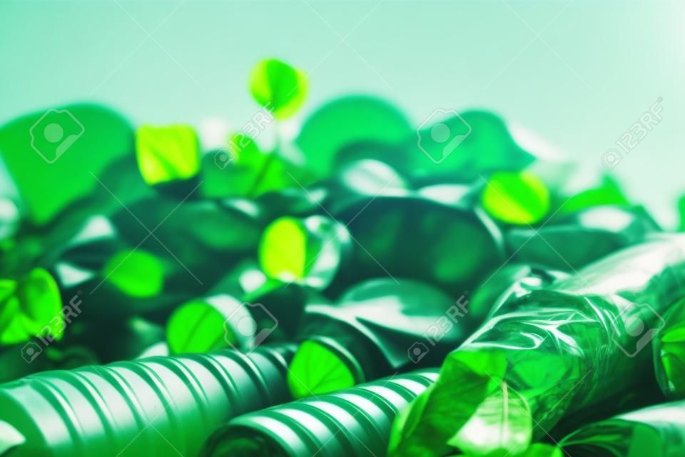 Viele Plastikflaschen und grüne Blätter stapeln sich auf weißem Hintergrund