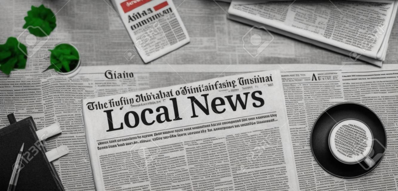 Een krant op een bureau met de kop Local News