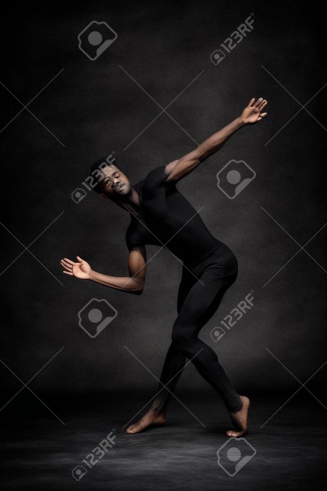 Ballerino di talento che mostra la sua flessibilità nello studio di colore nero