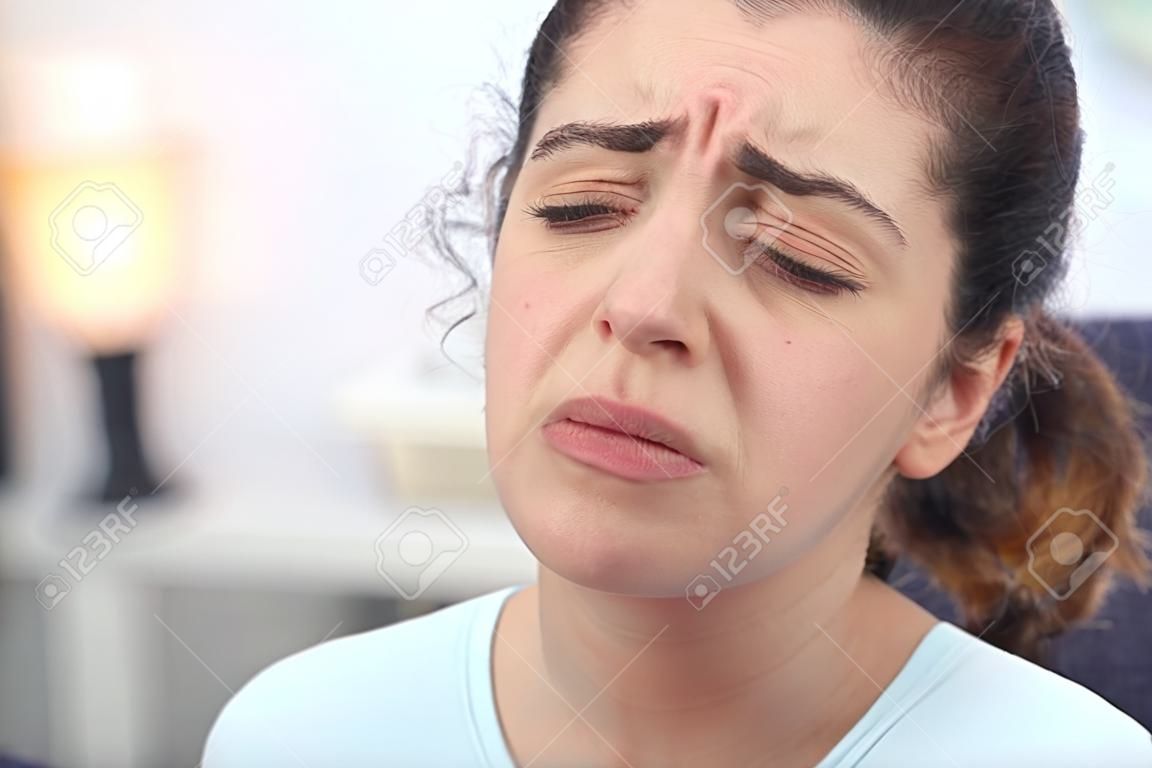 Jonge ziek uitziende vrouw fronsen haar gezicht terwijl ze lijdt aan koorts en seizoenskou