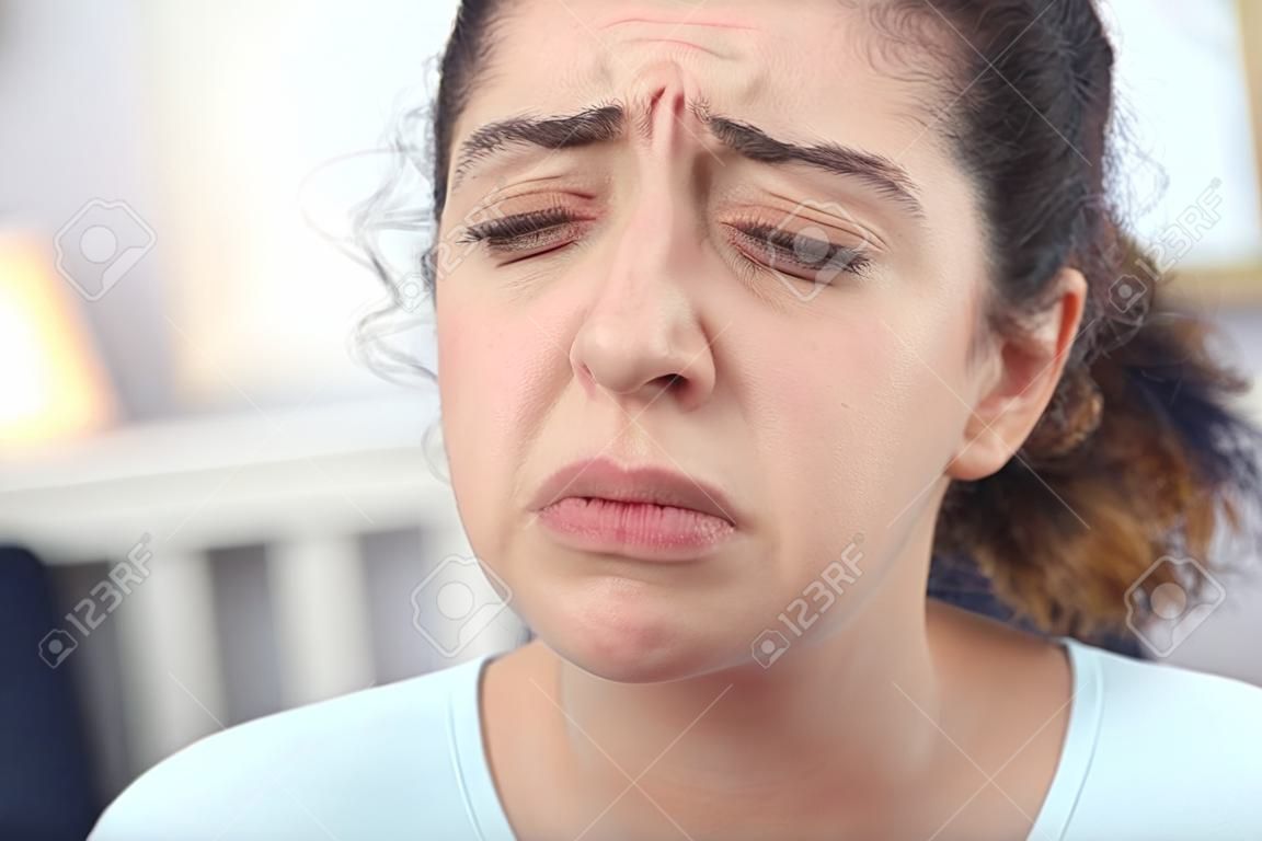 Jonge ziek uitziende vrouw fronsen haar gezicht terwijl ze lijdt aan koorts en seizoenskou