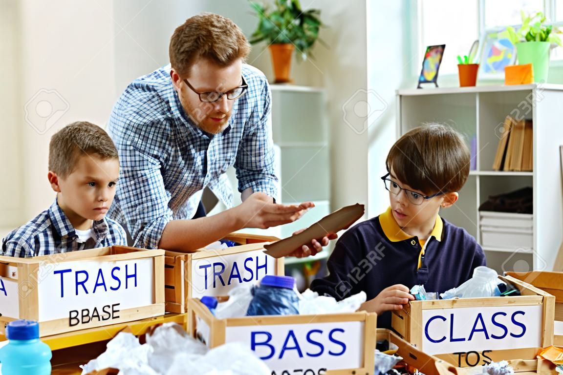 Grande professor. Professor atento em camisa quadriculada descrevendo bases de triagem de lixo para seus alunos