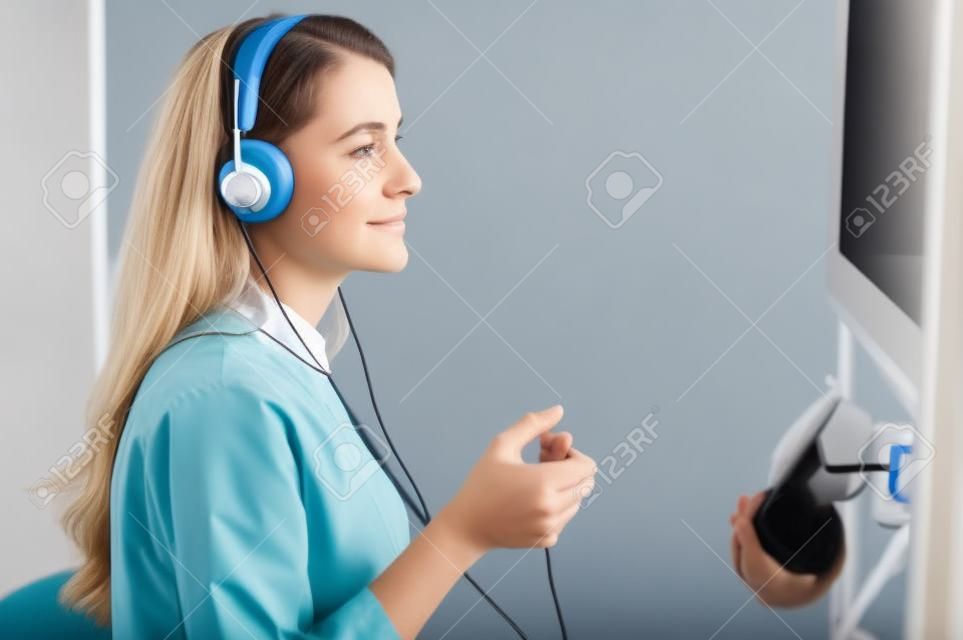 Paciente fêmea calma que submete-se a um teste de audição em uma clínica