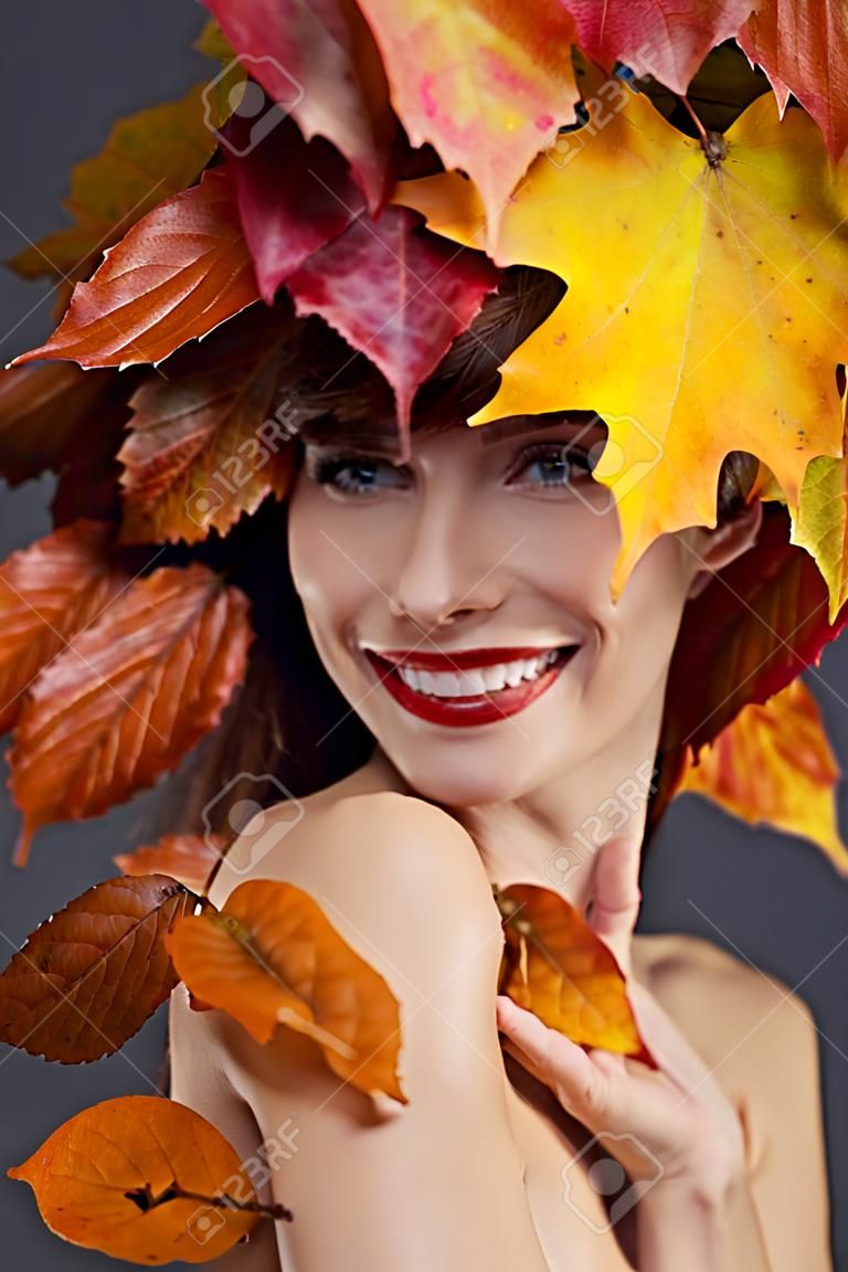 Woman with leafs on head in autumn concept.