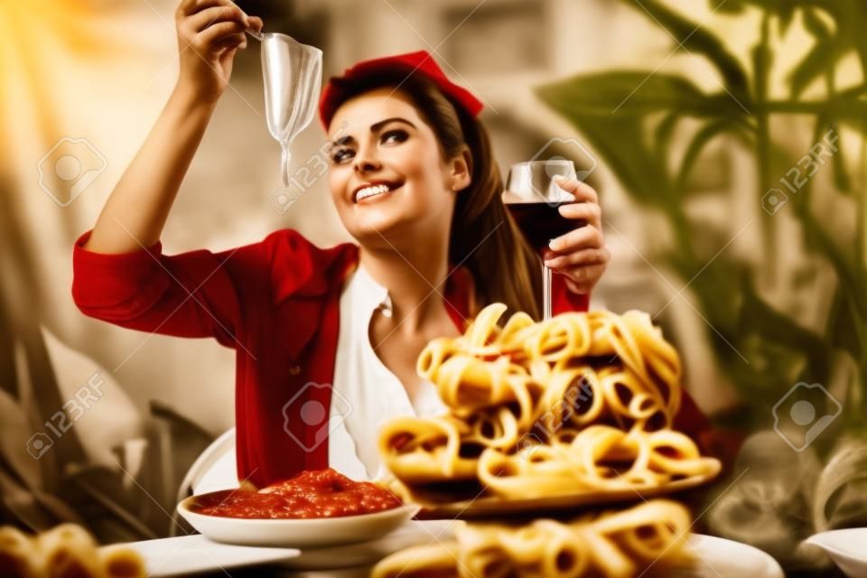 bw vintage ritratto di una donna italiana stile di vita che mangia pasta italiana con salsa di pomodoro e parmigiano, servita con un bicchiere di vino