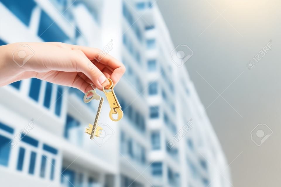 A real estate agent holding keys to a new apartment in her hands. Building under construction Real estate industry.