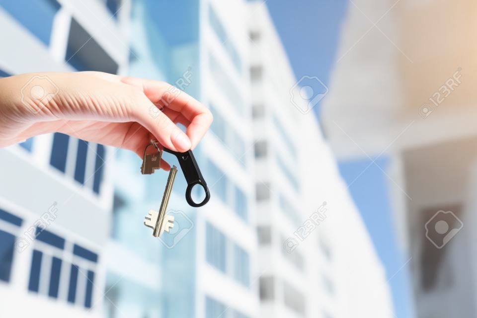 A real estate agent holding keys to a new apartment in her hands. Building under construction Real estate industry.
