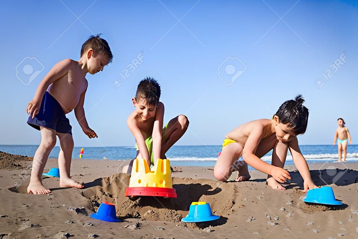 Spielerische Kinder auf Sommerstrand Sand Urlaub mit Spaß und glückliche Zeit