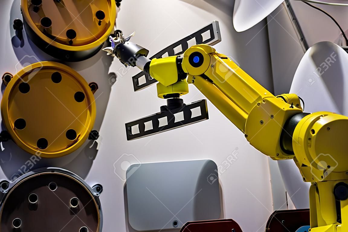 Il manipolatore automatico del braccio robotico con verniciatura a spruzzo gialla dimostra la funzionalità alla mostra sulla tecnologia dei robot intelligenti, alla fiera commerciale. Produzione, futuristico, concetto di produzione