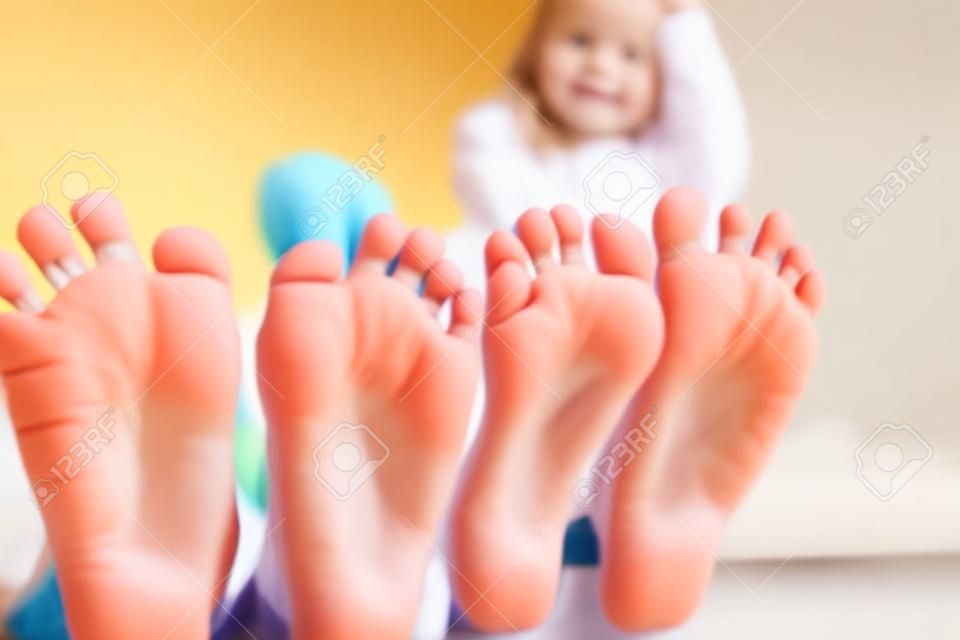 I piedi dei bambini si avvicinano alla telecamera. I loro volti sfocati sullo sfondo.