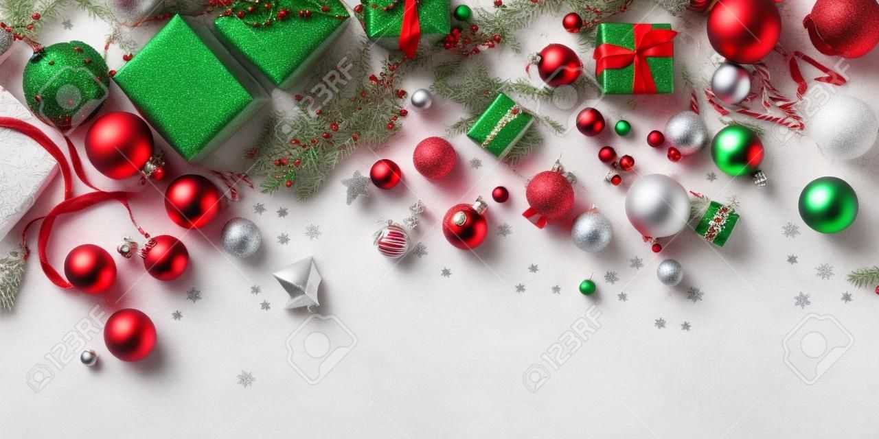 Una vista superior de una escena navideña festiva con varios accesorios dispuestos alrededor de los bordes de la imagen. Los accesorios incluyen elementos como luces navideñas, adornos, copos de nieve y otras decoraciones navideñas que crean una atmósfera cálida y acogedora.